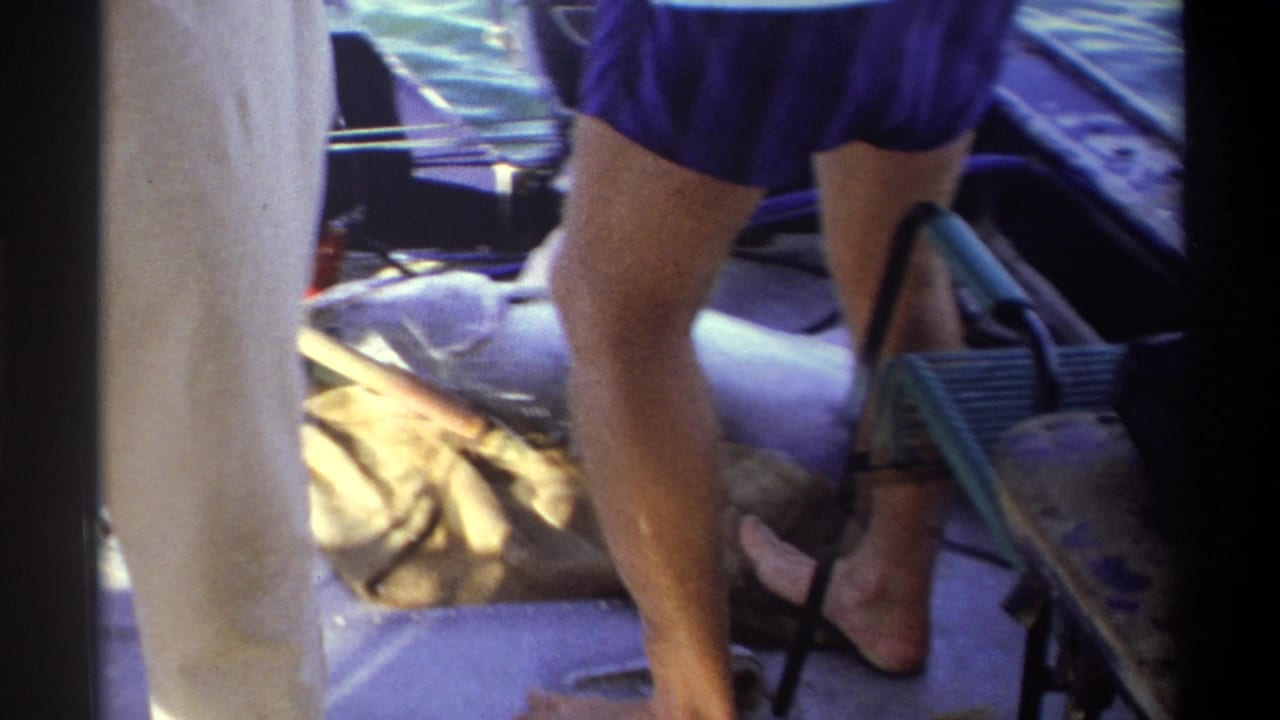 A large catch rests on the deck of a small boat in 1969 Nigeria, with adults and gear partly visible around it.