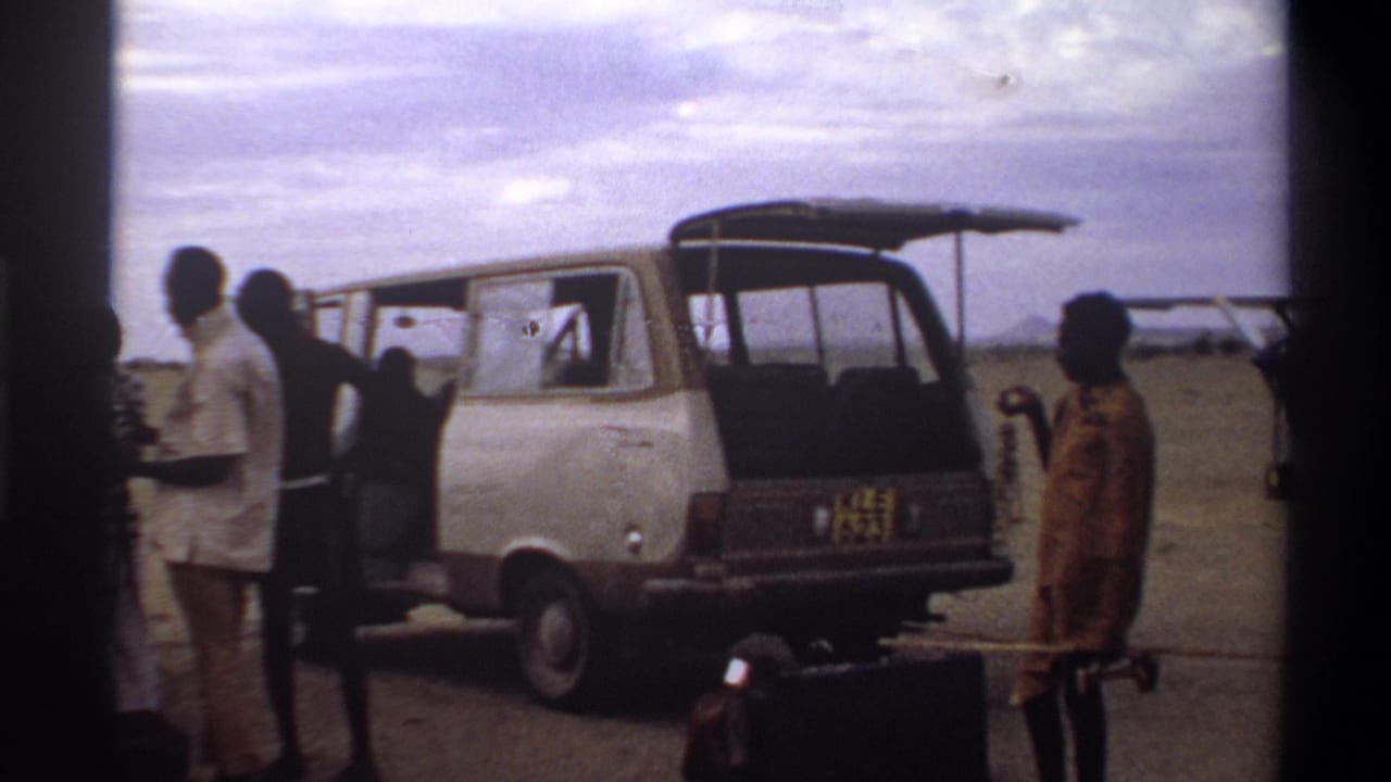 Men stand around an open-backed van at a Nigerian airstrip, with a small propeller aircraft visible in the distance.