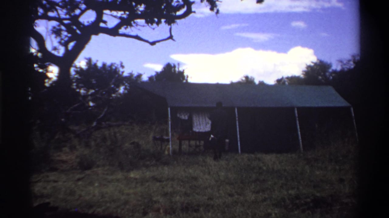 A wide 1969 Lagos frame shows the tented structure dominating the scene, with the luggage-carrying man reduced to a small figure nearby.