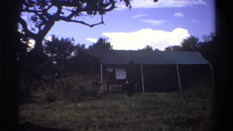 A wide 1969 Lagos frame shows the tented structure dominating the scene, with the luggage-carrying man reduced to a small figure nearby.