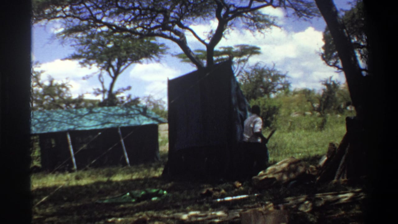 Near the end of the clip, a man stands by the raised tent or awning panel in the 1969 Lagos outdoor scene.