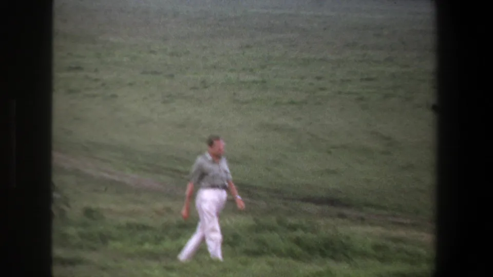 The man continues across the Pretoria grassland, seen at a distance in soft 1969 8mm color footage.