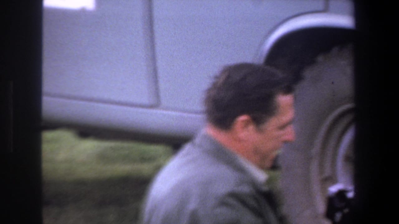 Adult man in profile near the wheel of a light utility vehicle.