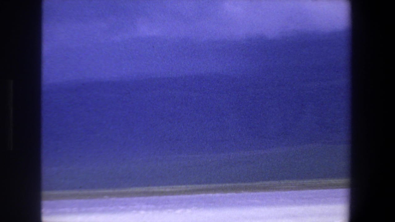 Blue lake surface with a pale shore band and no clearly visible birds.