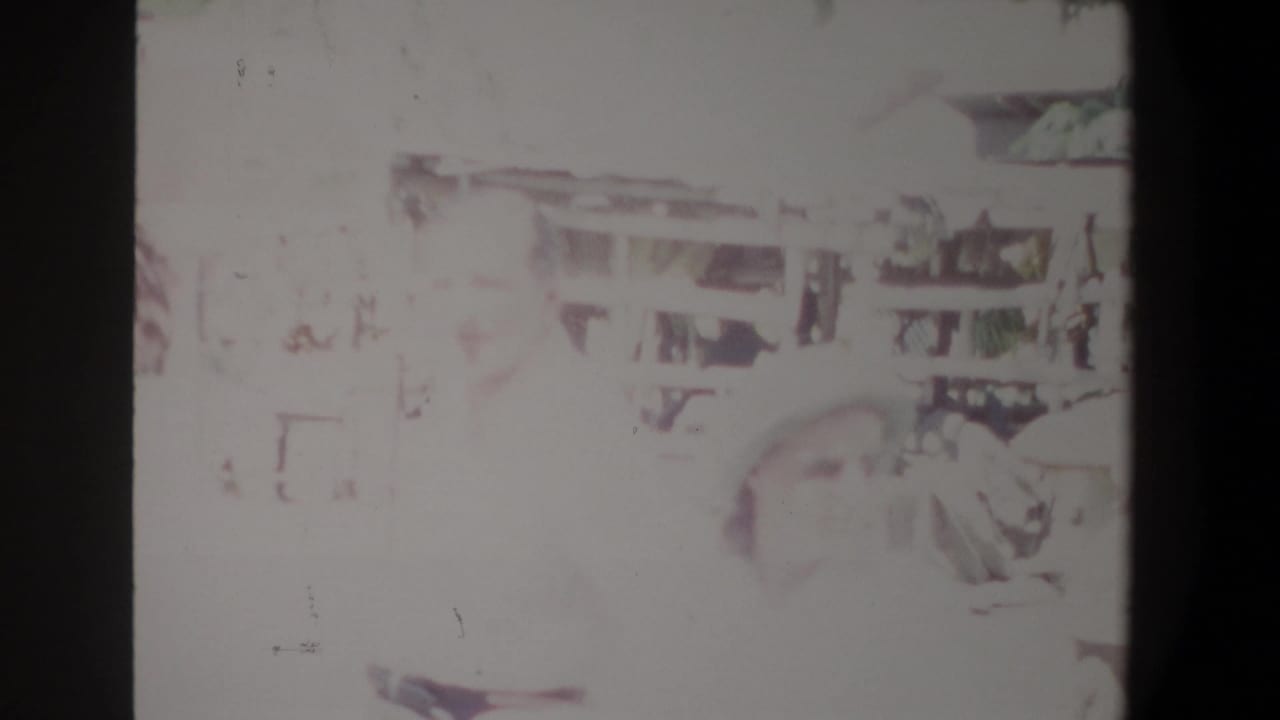 Overexposed Pretoria market frame with a figure near the right side and faint stall details behind them.