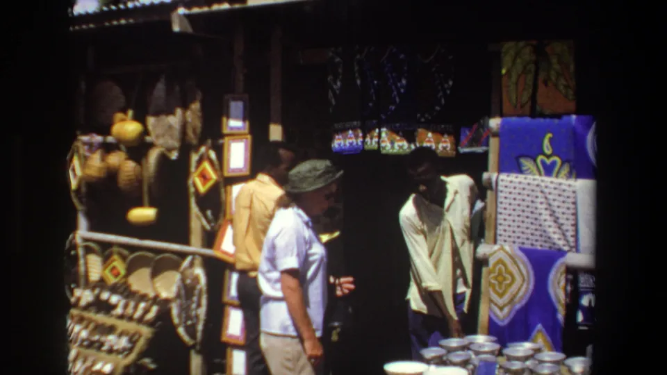 The Pretoria 1969 market scene shows the vendor leaning toward stacked bowls as the woman remains beside the craft display.