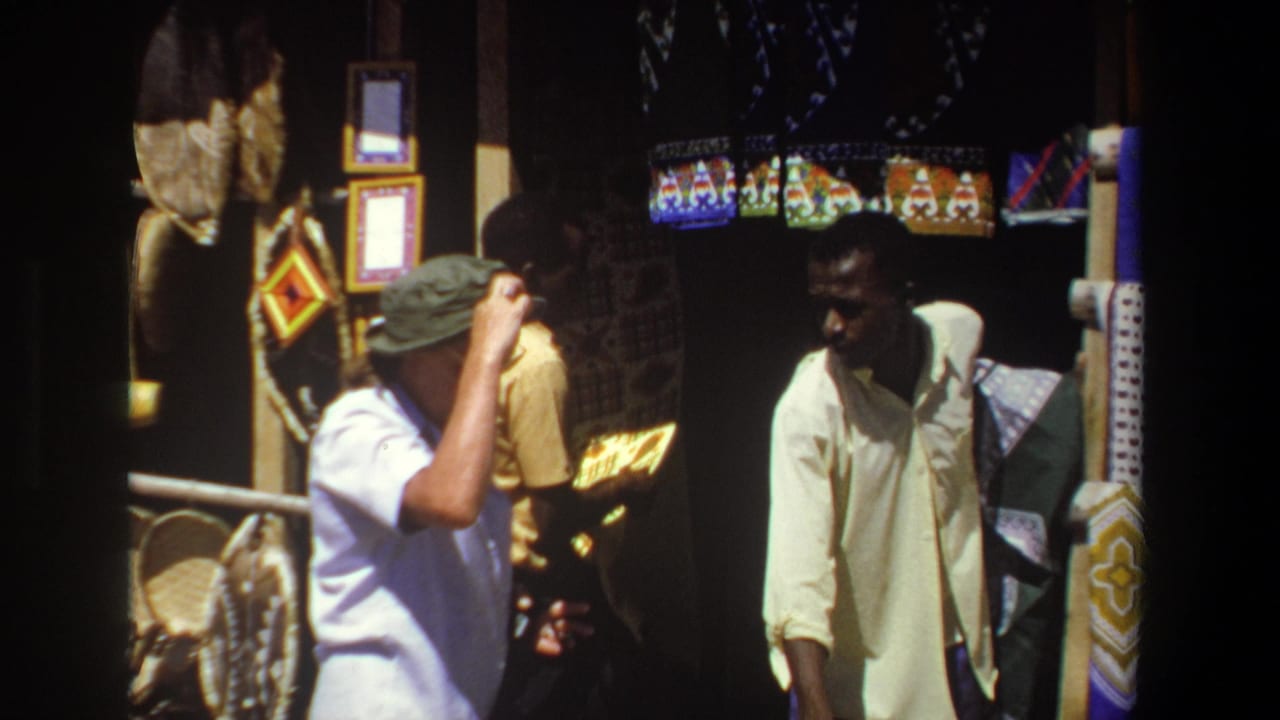 In the Pretoria market scene, the visitor raises a hand to his green hat as the vendor stands beside colorful hanging textiles and craft displays.