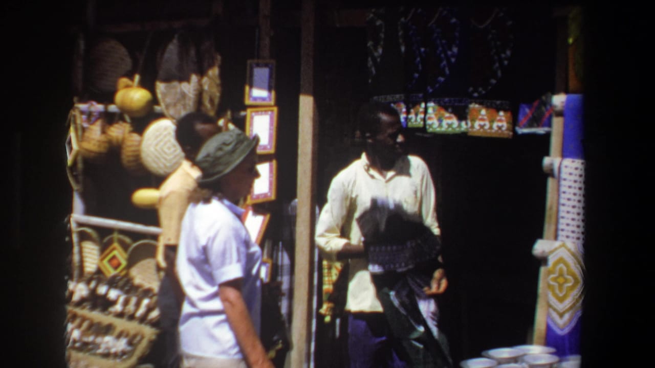 In the Pretoria market scene, the cloth seller lifts a dark textile toward the woman while colorful fabrics and baskets hang nearby.
