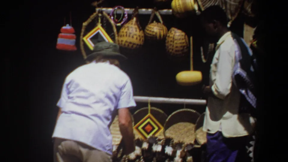 A 1969 Pretoria market view shows a visitor inspecting woven goods as another man stands beside the craft display.