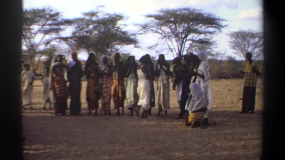 1969 Khartoum frame showing an outdoor gathering of women in wraps and head coverings, filmed with handheld 8mm texture.