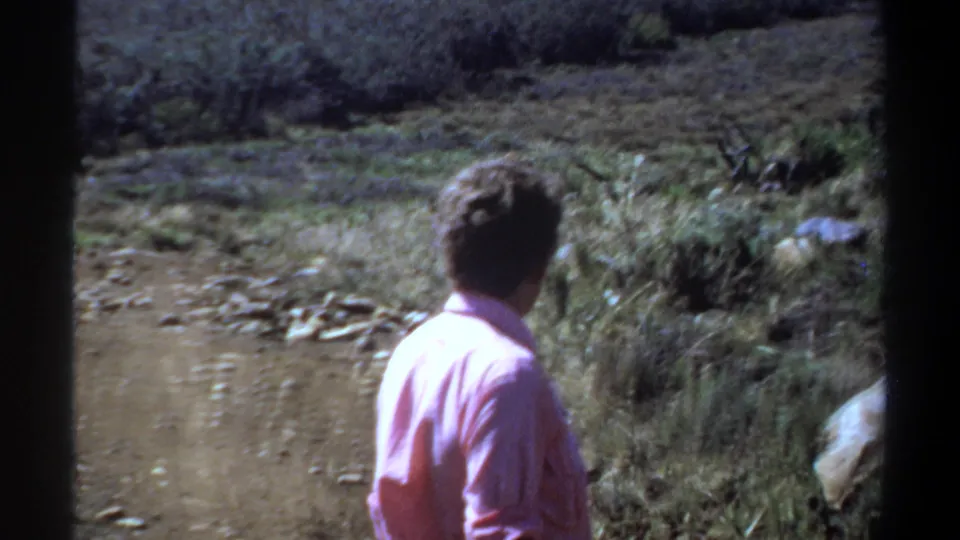 1969 Khartoum frame showing the man from behind as he continues along a dry dirt path.