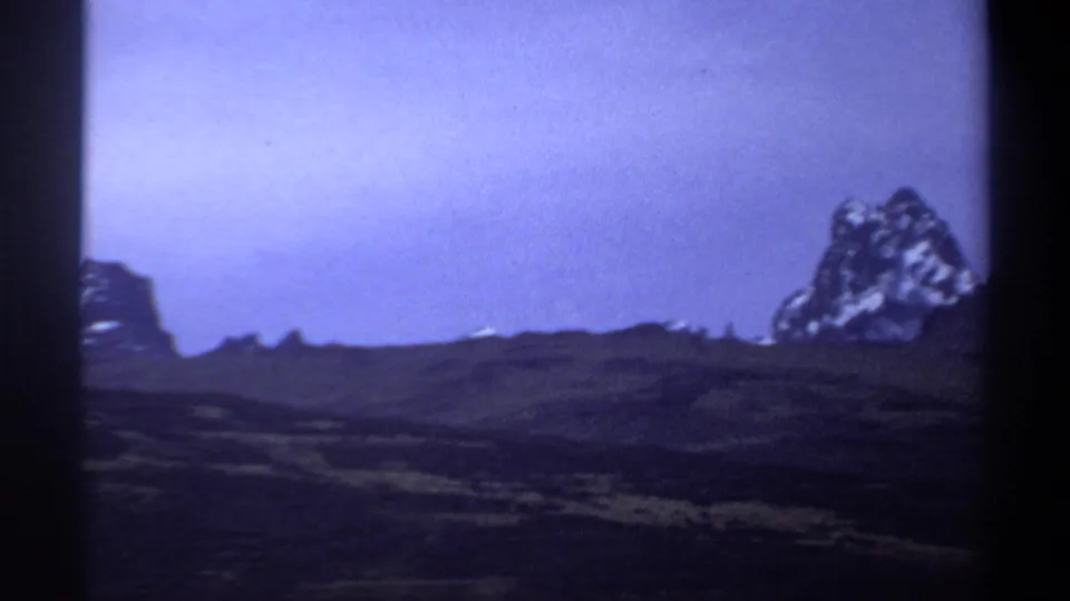 A distant rocky outcrop appears at the right edge of a 1969 Sudan home-movie landscape frame.