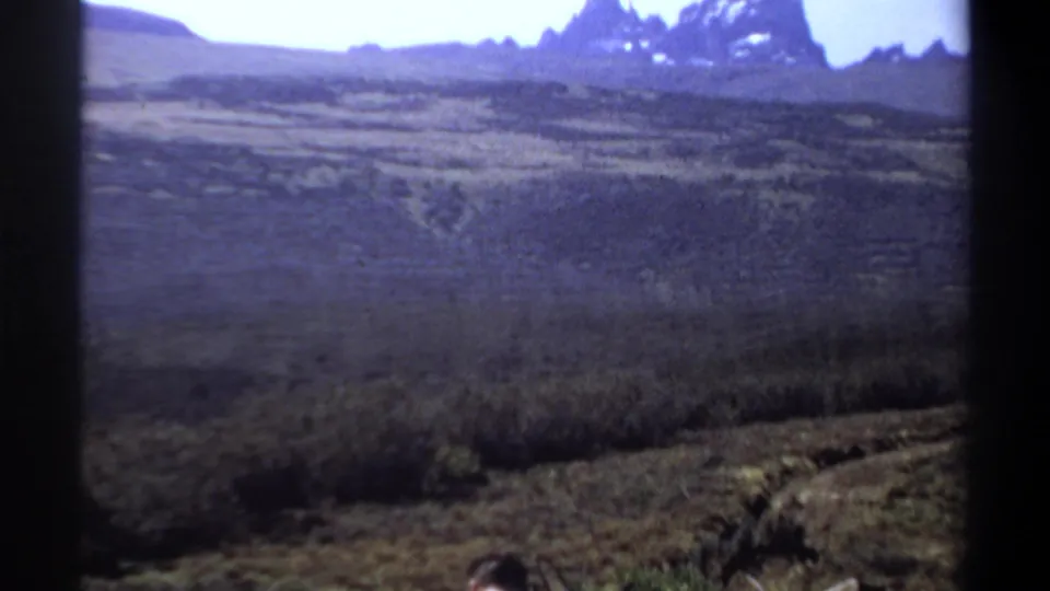 A wide 1969 Sudan landscape view shows arid ground and distant mountains, with part of the photographer visible near the lower edge.