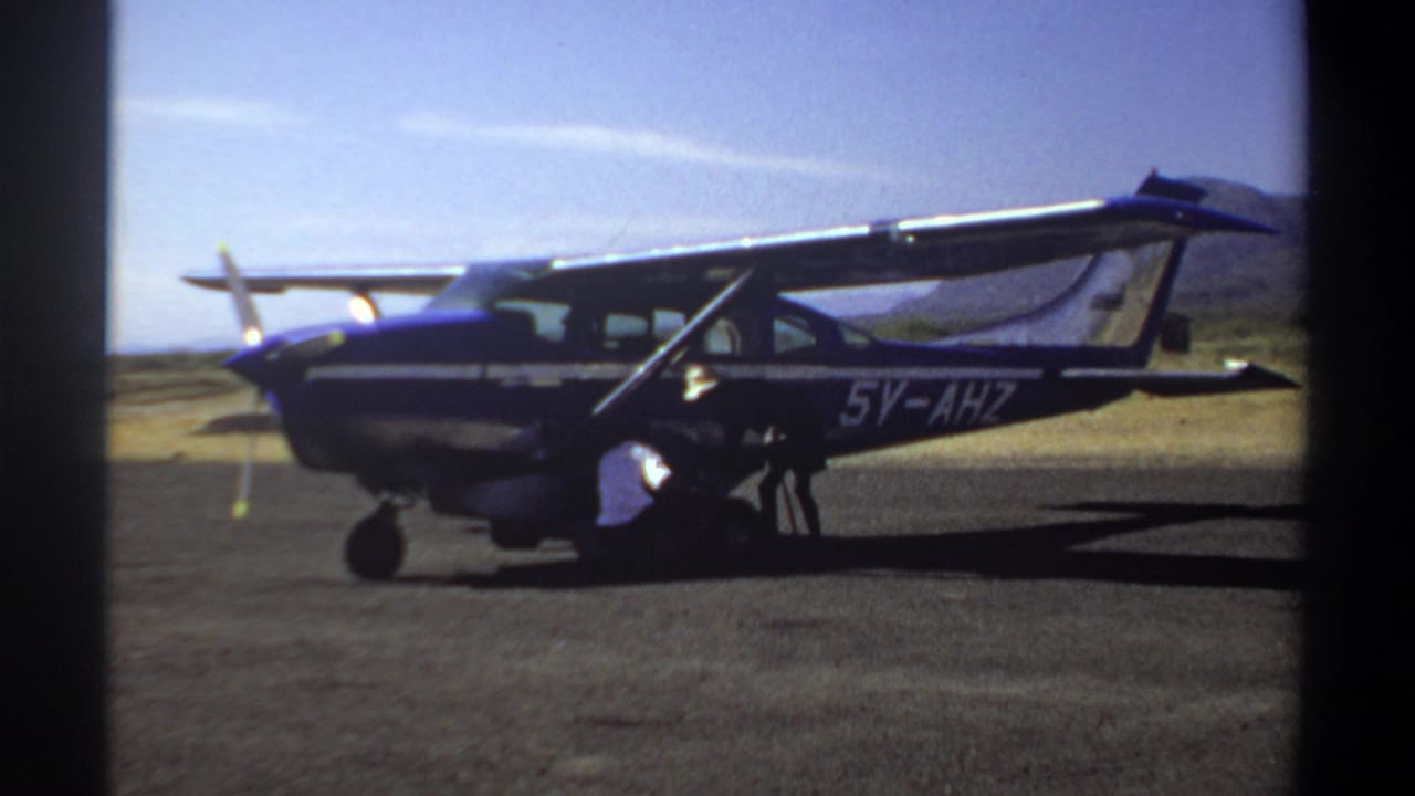 Small aircraft side view with registration visible and a person working near the front wheel area.