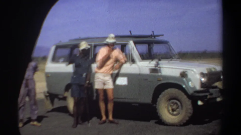 At the end of the clip, the visiting man appears to gesture while standing with two local men beside the Land Cruiser in Khartoum.