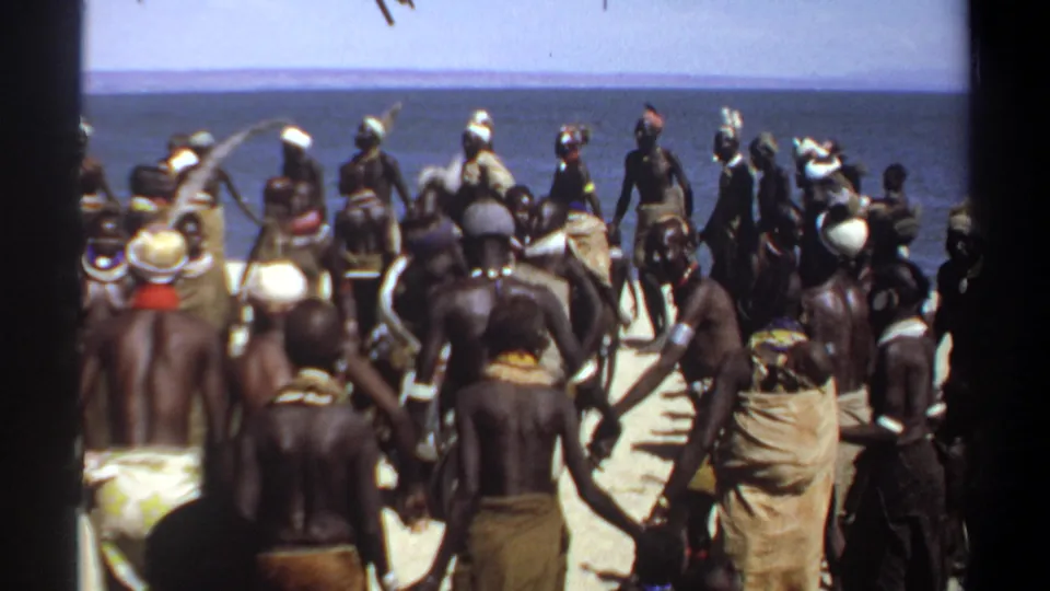 1969 Khartoum, Sudan home-movie frame showing a crowd in wraps and head coverings gathered near the water's edge.