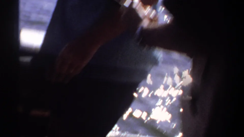 Hands and a fish are partially visible in deep shadow inside the boat, with bright reflected water at the edge of the frame.