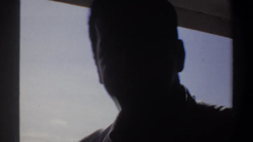 A dark foreground silhouette inside the boat partly blocks the bright exterior, suggesting people gathered around the view.