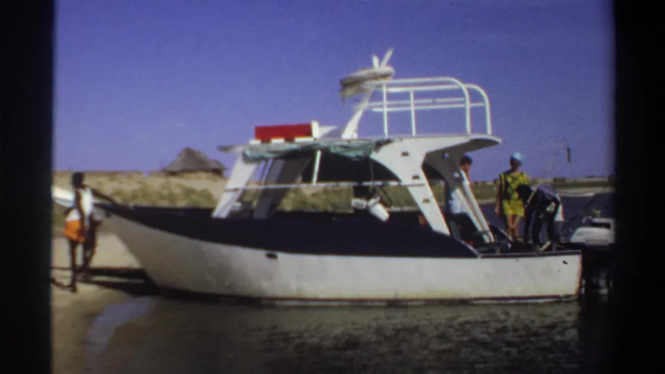 Several people are visible around a white powerboat at the Khartoum waterfront in 1969, with the vessel close to a dock or landing.