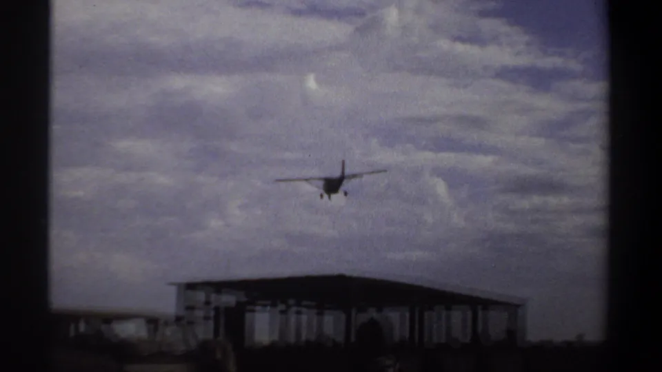 Small aircraft appears above a low open-sided airport shelter in Khartoum, Sudan, in 1969 footage.