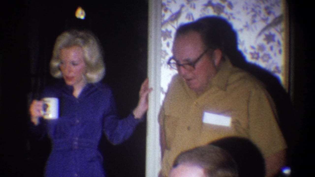 Blonde woman holding a mug stands near a man in a yellow shirt with a name tag.