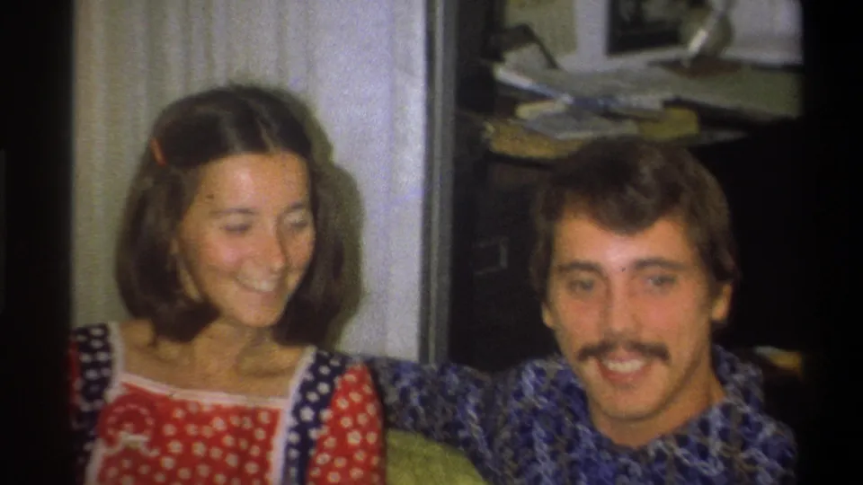 The final frame shows the couple seated close together, smiling in a softly focused 1973 Troy, New York home interior.