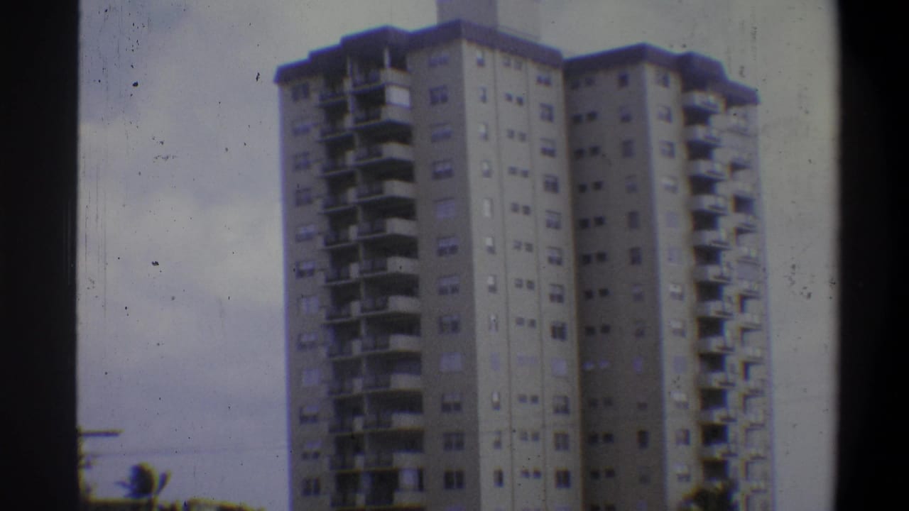 Tall concrete residential tower with horizontal balconies and window grid, Troy, New York area, circa 1973, filmed on 8mm.
