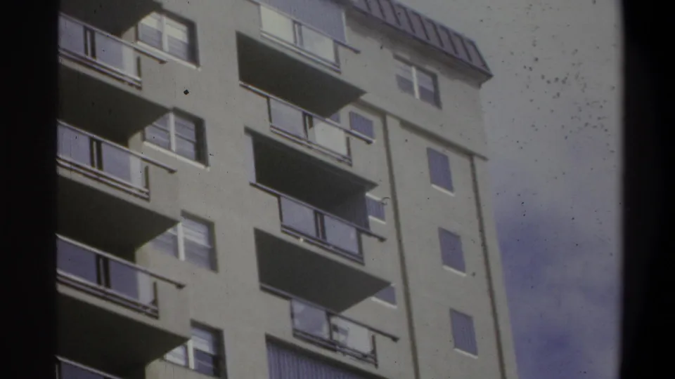 8mm home movie close-up of a light-colored multi-story building with horizontal balconies, likely a US coastal resort or hotel, circa 1973.