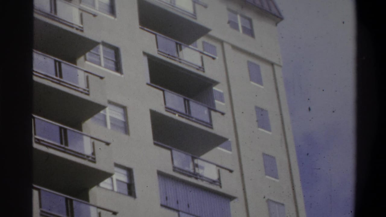 Slightly reframed close-up of the same balconied multi-story building, windows and railings filling the frame.