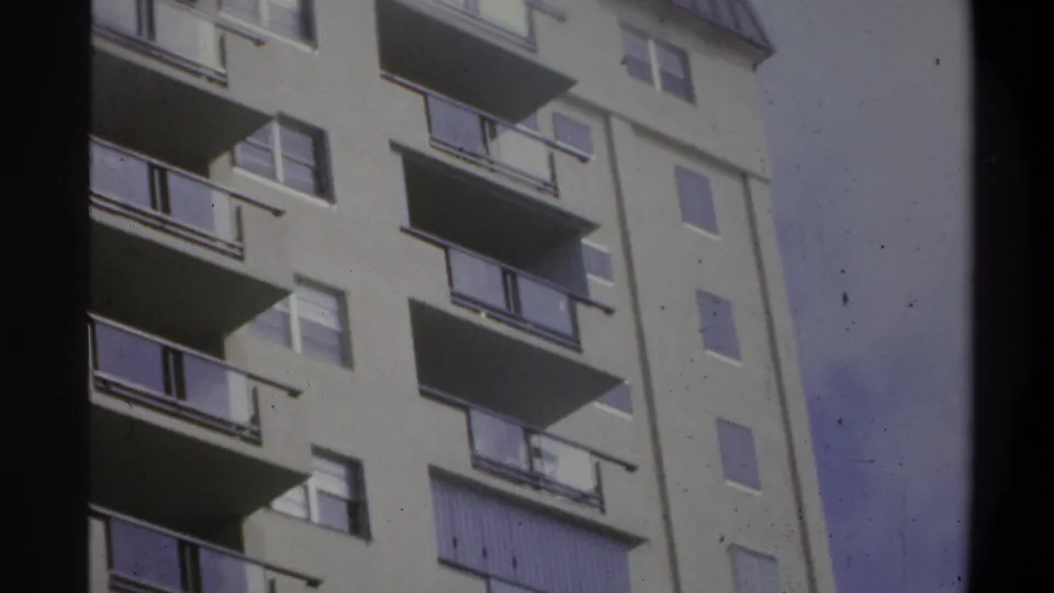 8mm film frame of a balconied high-rise building exterior, consistent with a 1970s American resort or apartment complex, circa 1973.