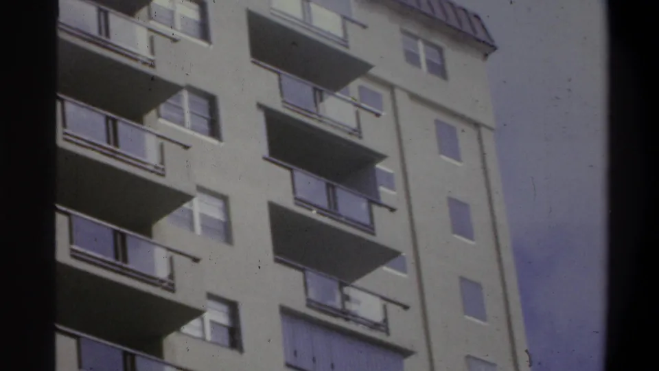 8mm home movie showing the upper floors and roofline of a balconied building, possibly a beachfront hotel, circa 1973.
