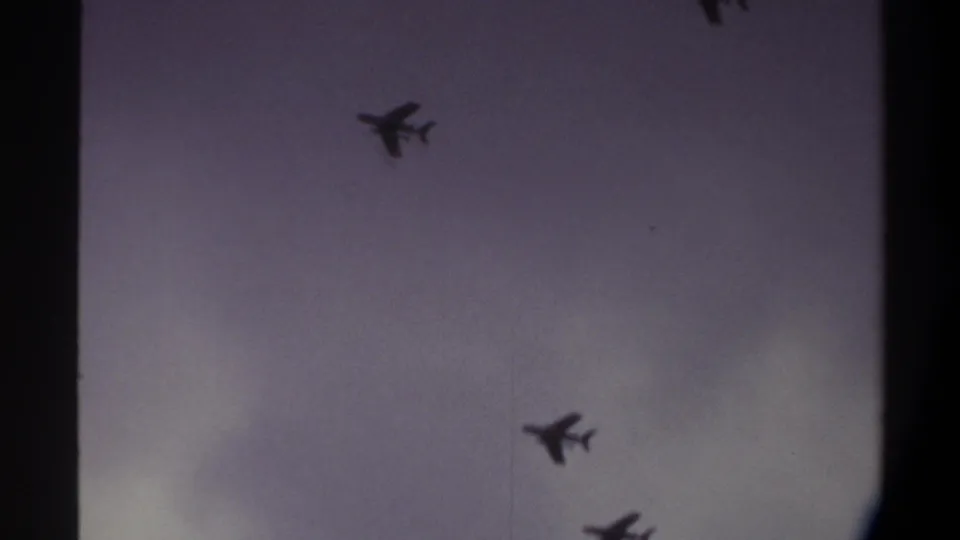 Two jets against an overcast sky on aged 8mm film, Gainesville, Florida area, 1974; color cast and grain clearly visible.