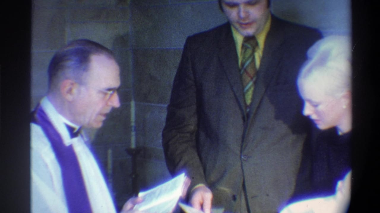 Officiant in white vestments reads aloud as groom and partially visible bride stand in reverence; 8mm footage, Gainesville, Florida area, circa 1974.