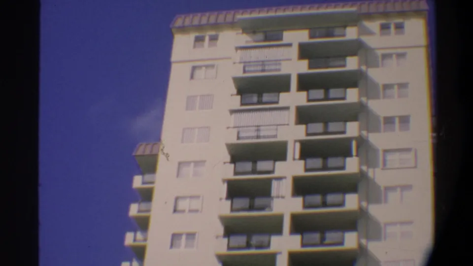 Roofline of a multi-story condominium in Gainesville, Florida, circa 1974; camera tilt completes with the building top and deep blue sky prominent.