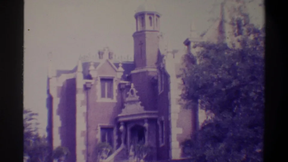 Gothic Revival brick building, possibly Gainesville, Florida, 1974 — cylindrical tower, ornate porch, summer trees; characteristic 8mm purple color shift.