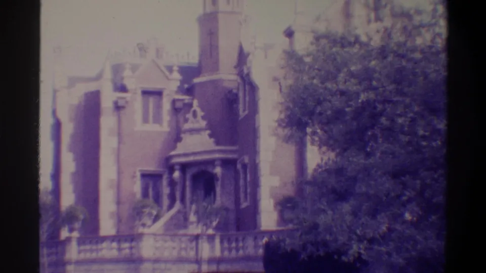 Gothic Revival building, Gainesville, Florida, 1974 — wider framing reveals decorative fence in foreground and fuller view of ornate porch; purple 8mm.