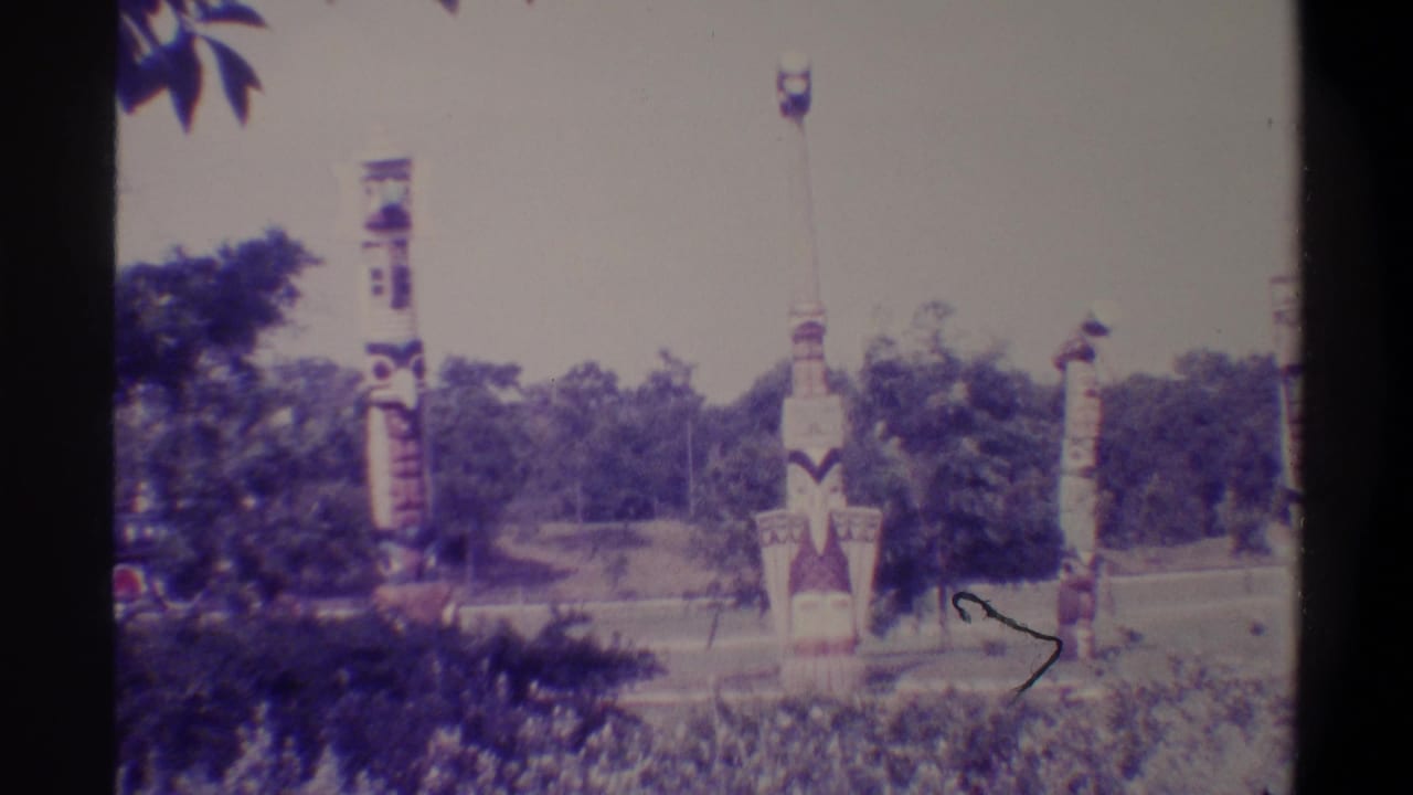 Multiple painted decorative totem-style columns in a park setting, Gainesville Florida area, 1974, shot on 8mm home movie film