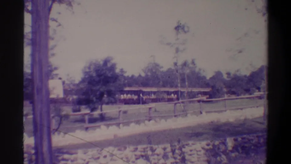 Final 8mm frame from Florida tourist attraction, c. 1974, with the ride train in far distance and a possible visitor figure visible at the right edge.