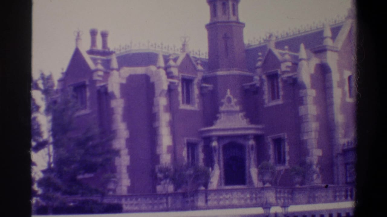 Gothic Revival building with pointed turrets, stone quoin detailing, and ornate dormer pediments; heavy purple-magenta cast from aged film emulsion.