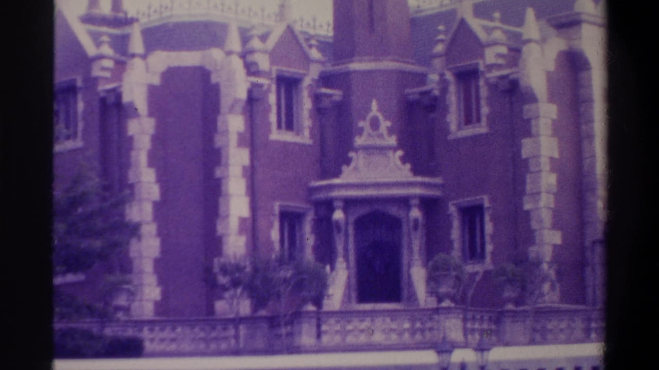 8mm film still from 1974 Florida showing Gothic Revival building facade with ornate decorative window pediment, stone trim columns, and pointed turret; characteristic emulsion color shift.