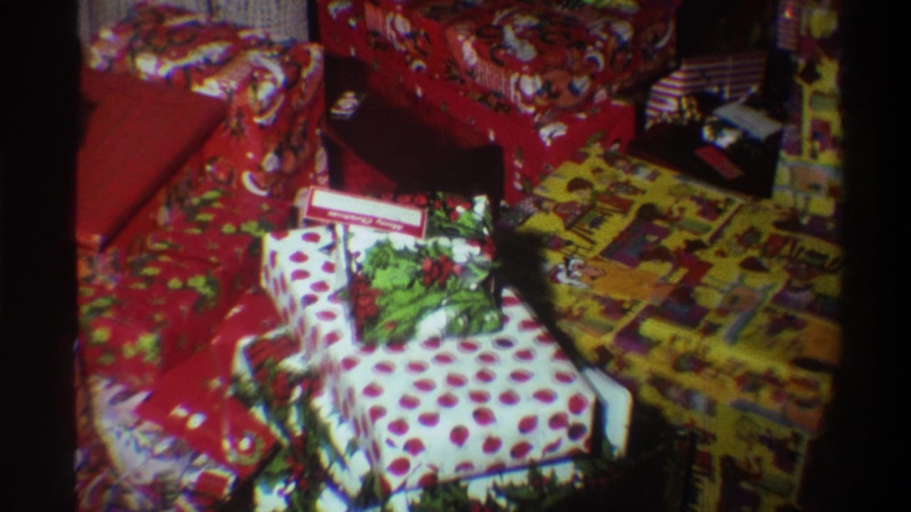 Christmas gifts in polka-dot and yellow illustrated wrapping papers with a gift tag visible as camera pans across the pile.