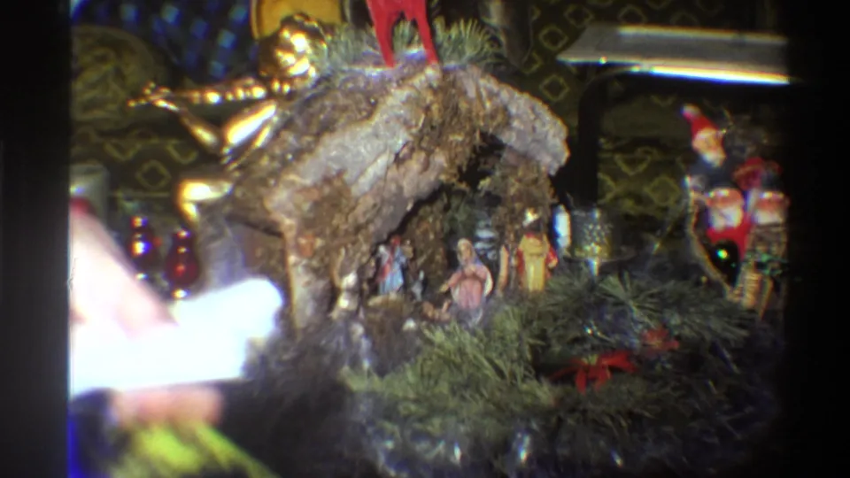 8mm home-movie frame of a nativity crèche interrupted by a light flare, a common artefact of amateur mid-1970s filming.
