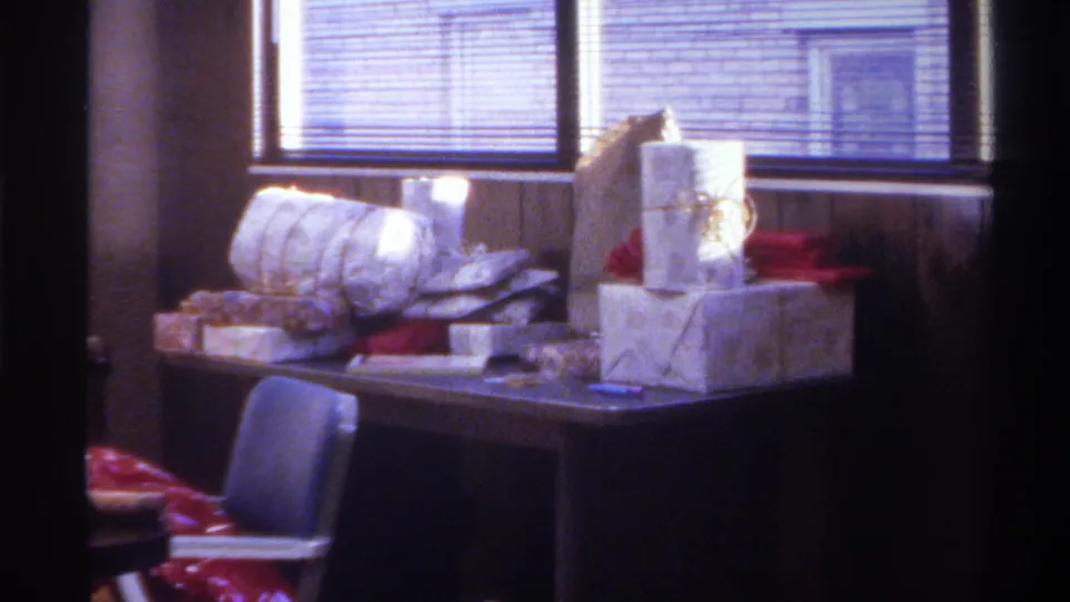 Final frame of gift display on table with venetian blinds and grey chair visible; Gainesville, Florida, 1975, 8mm home movie.