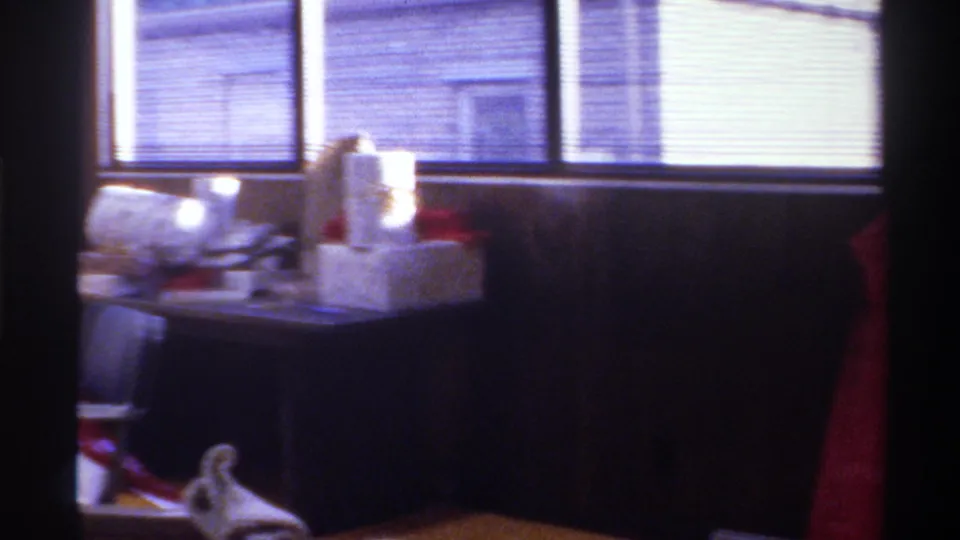 Table covered in Christmas presents and wrapping materials in a wood-paneled 1970s home interior, Gainesville, Florida, circa 1975.