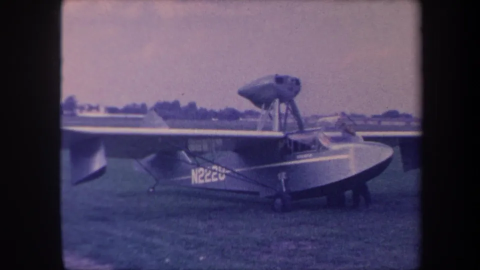 Amphibious flying boat N222U at ground level on grass airfield, California circa 1959; boat hull, strut-mounted landing gear, and propeller visible.