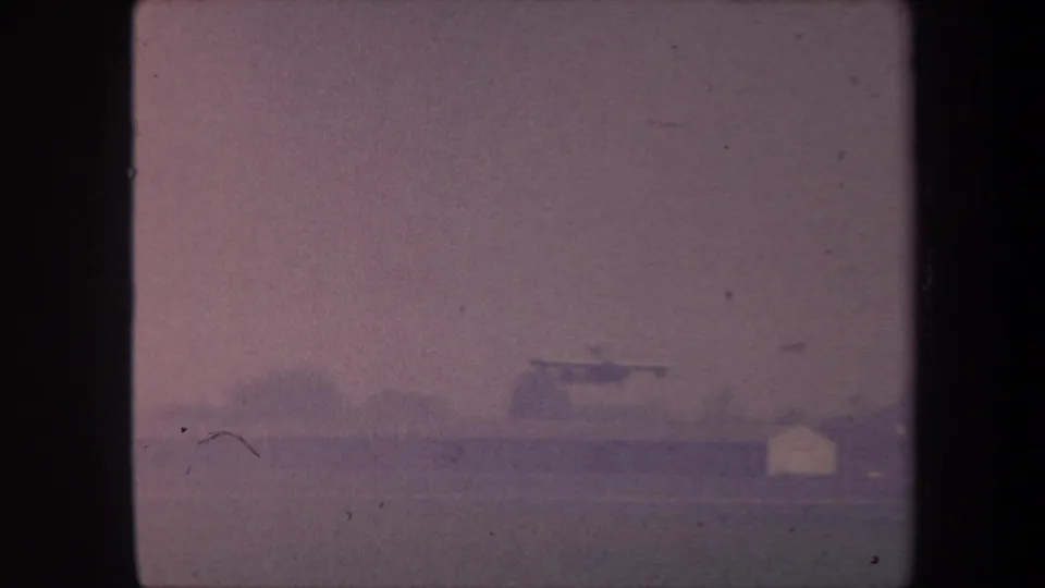 8mm home movie frame circa 1959, possibly Yucaipa California: hazy purple sky over flat landscape with possible distant structures at lower-right horizon.