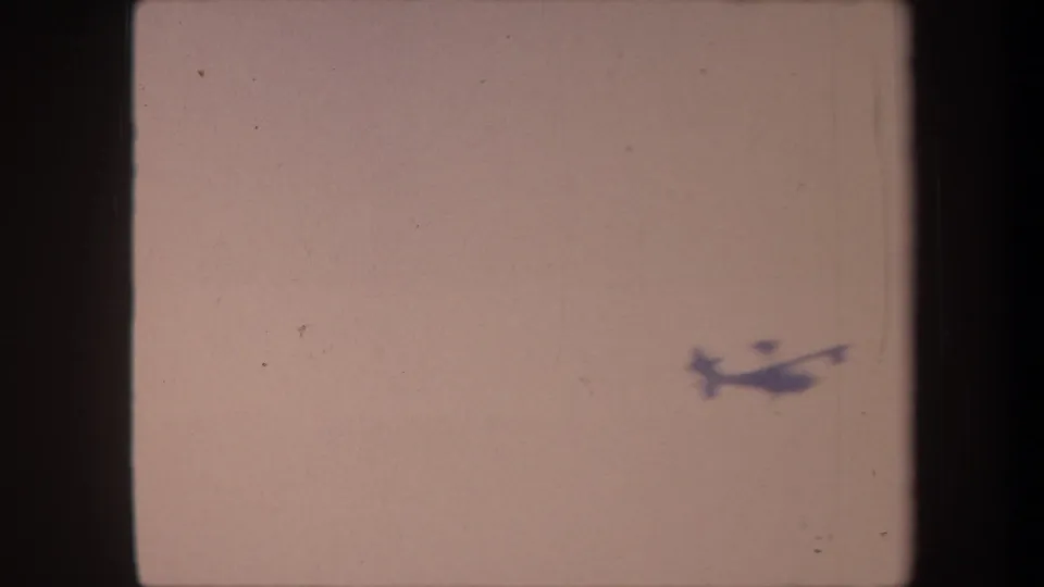 Propeller aircraft at lower-right of frame, smaller as it distances itself; 8mm home-movie, Yucaipa, California, 1959.