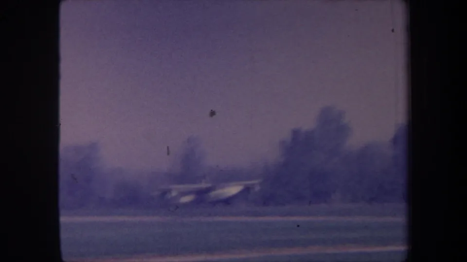 Small seaplane on a grass airstrip, possibly Yucaipa, California, circa 1959; 8mm home-movie footage with characteristic blue-purple color drift.