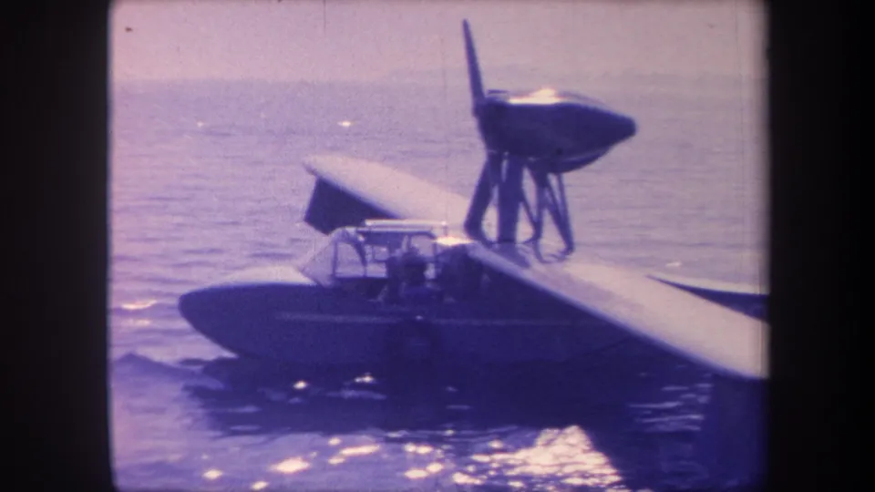 8mm home-movie frame, c. 1959, showing a single-engine flying boat on open water in California; no person clearly visible in this frame.