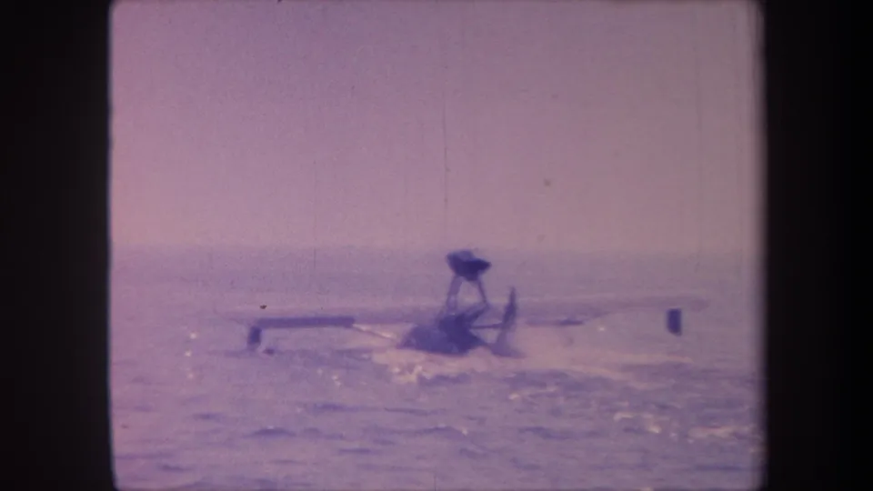 The floatplane continues across the water surface in the clip's final seconds, filmed in California circa 1959 on 8mm with heavy purple dye shift.